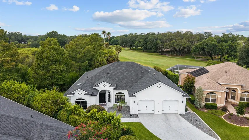 Aerial perspective highlights the home’s attractive exterior, established landscaping, and desirable location directly along the golf course.