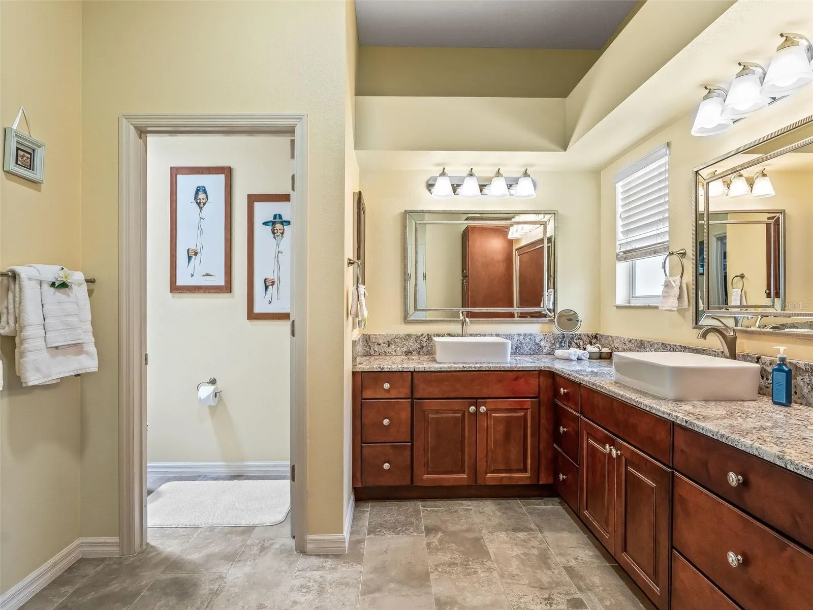 A spacious vanity layout with ample storage and counter space creates a functional and comfortable setting for daily routines.