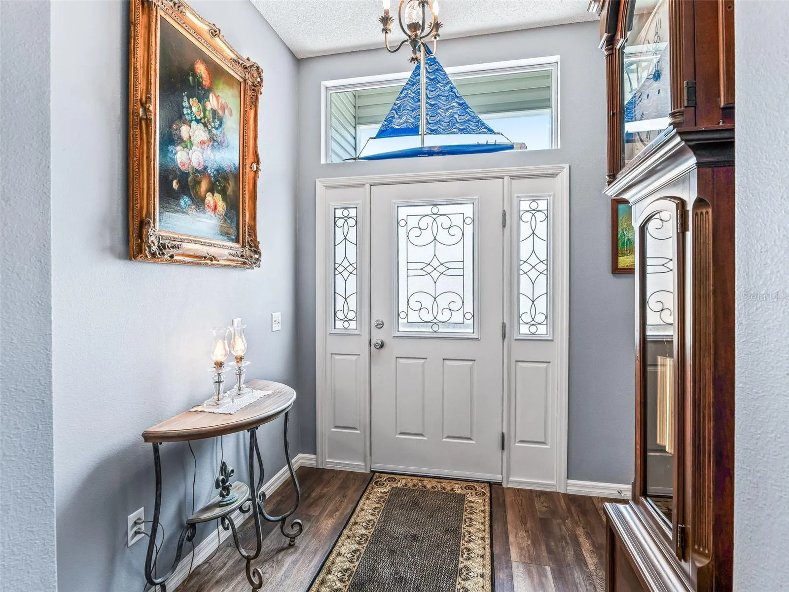 Decorative glass front door with matching sidelights and transom window fills the entry with natural light and creates a polished first impression.