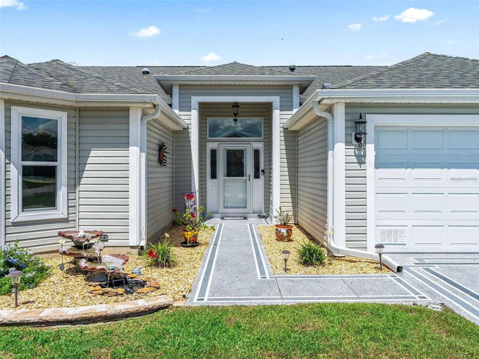 Welcoming covered entry with glass-accented front door, sidelights, and a decorative walkway offers a polished first impression.
