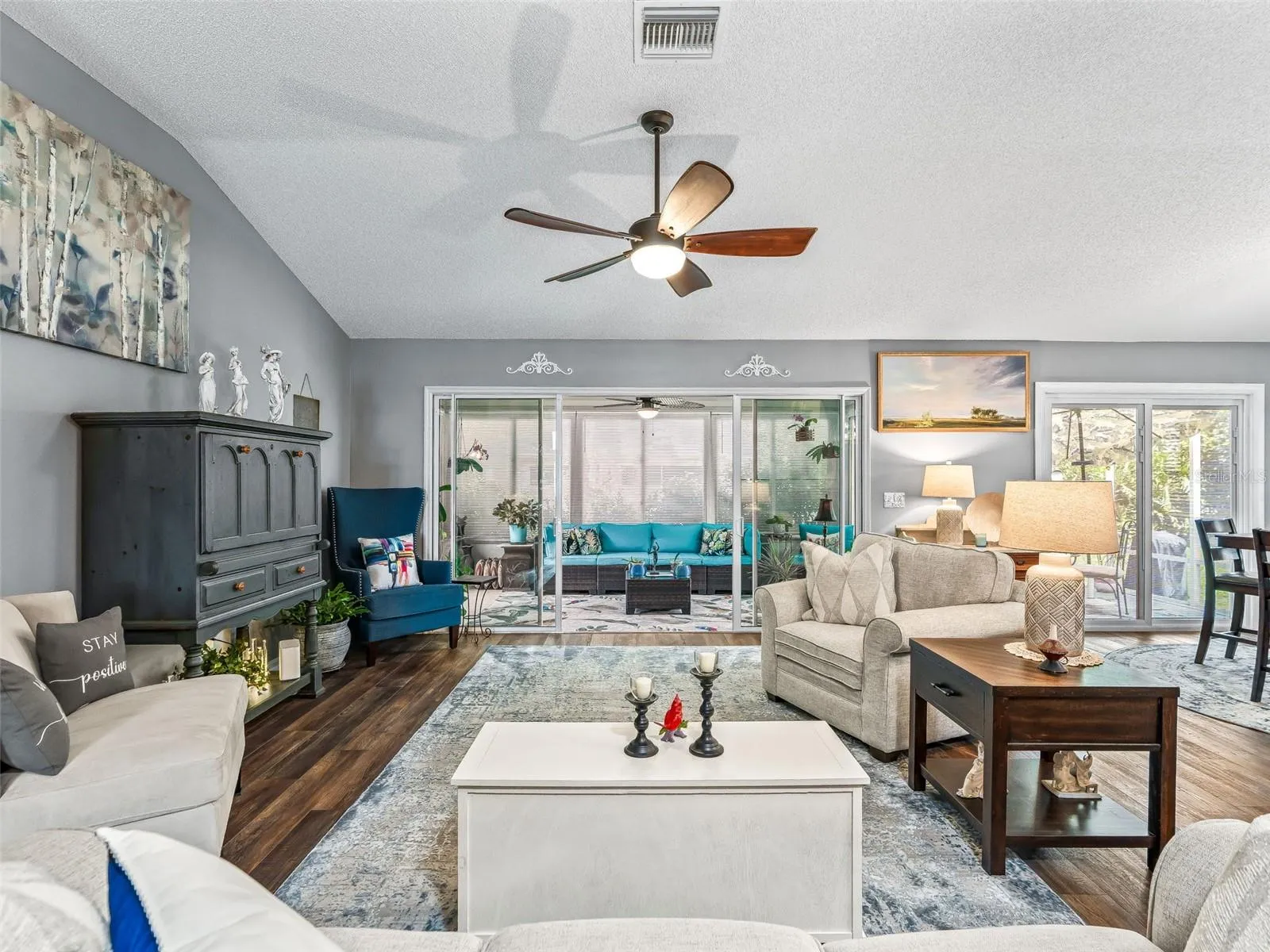 Large windows and sliding glass doors brighten the main living area while providing a pleasant view toward the enclosed rear living space.