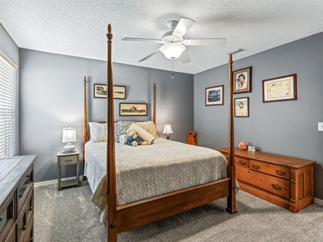 The spacious secondary bedroom with closet, provides room for a full furniture arrangement, along with a ceiling fan, and ample natural light.