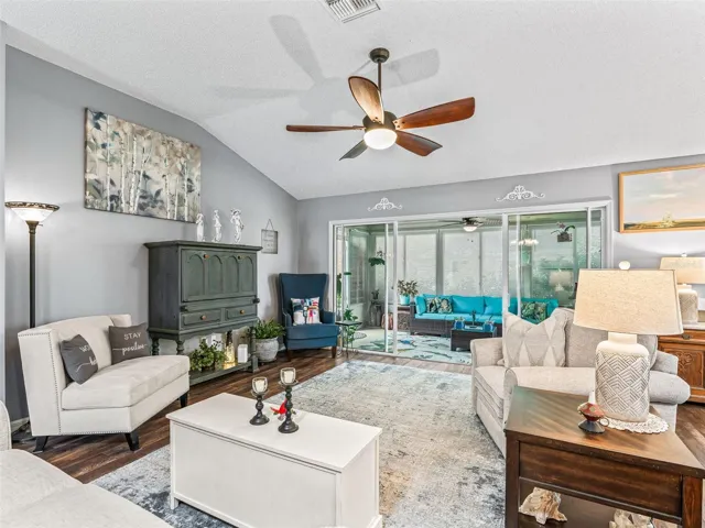 Generously sized gathering space features a vaulted ceiling, warm flooring, and a flexible layout for multiple seating arrangements.