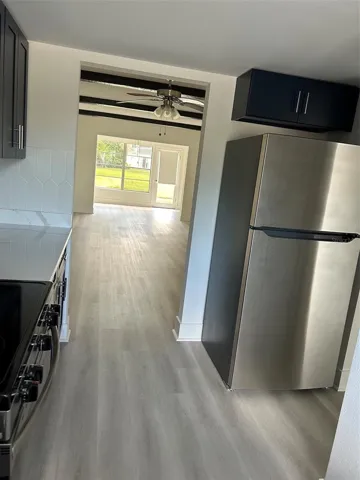 Looking from kitchen through dining and living areas to the Florida room and back door beyond.