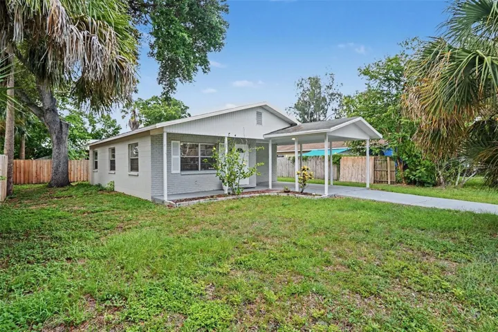 Fresh curb appeal with concrete block construction and a covered carport.