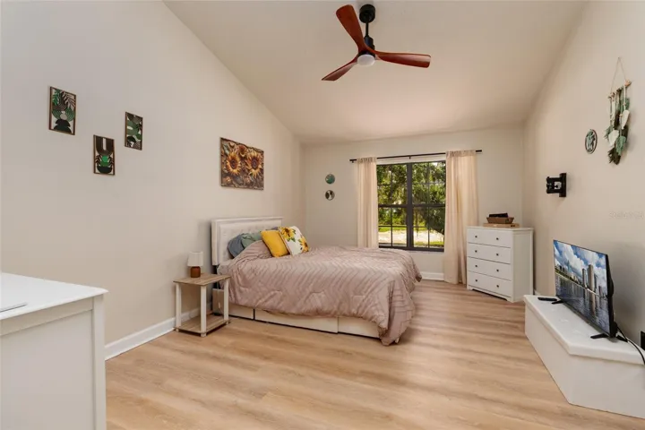 master bedroom with view of backyard tree and lake