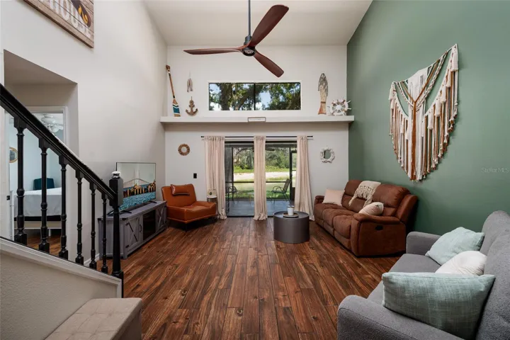 living room with stairs to second floor and view of sliding glass doors