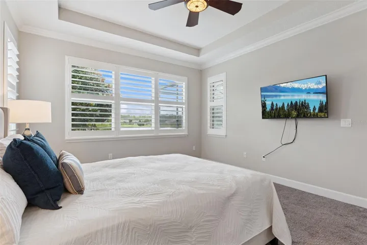 Primary Bedroom w/ wall mounted flat screen TV & a Pond view