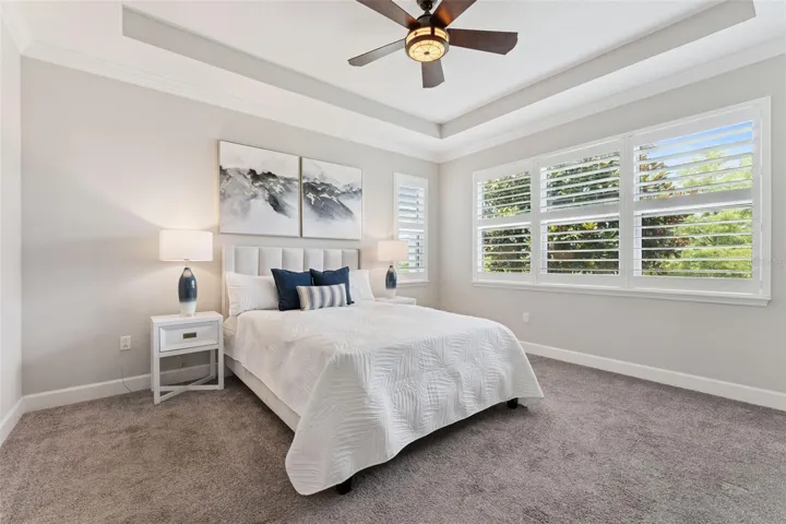 13' x 15' Primary Bedroom w/ tray ceiling, ceiling fan & Plantation style shutters