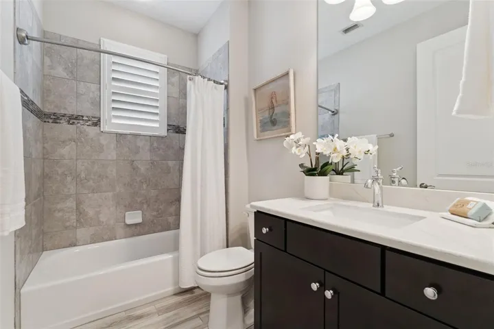 Guest Bathroom w/ Quartz countertop vanity & tub/shower combo.