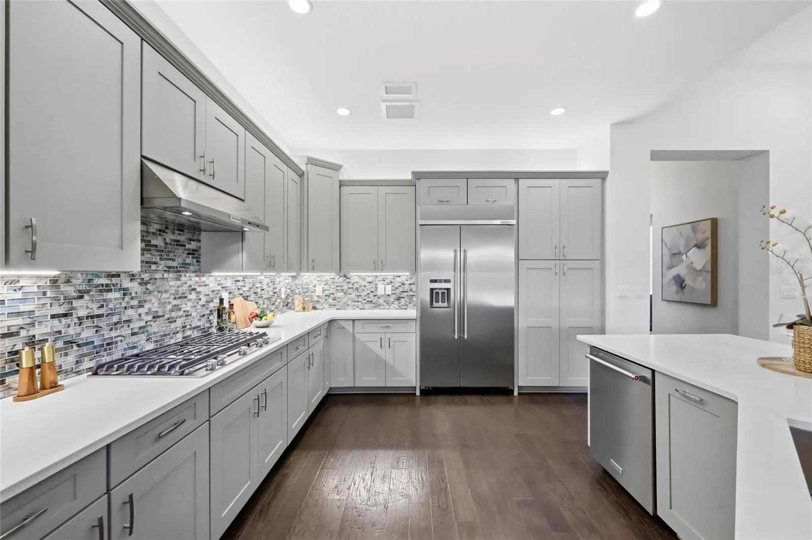 Thoughtfully Designed  Kitchen with Quartz Counter tops, Glass tile Back Splash, Upgraded Natural Gas Range, Upgraded Cabinets, and Oversized Island