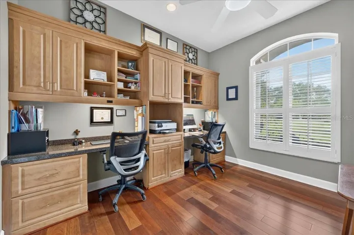 Near the front entry, the dedicated office features plantation shutters, built-in cabinetry and ample workspaces.