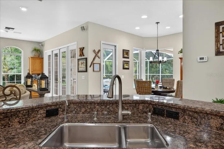The spacious, well-appointed kitchen features abundant oak cabinetry, granite countertops, stainless steel appliances, a gas range, wine storage and an elevated breakfast bar with seating overlooking and flowing seamlessly into the family room and breakfast nook.