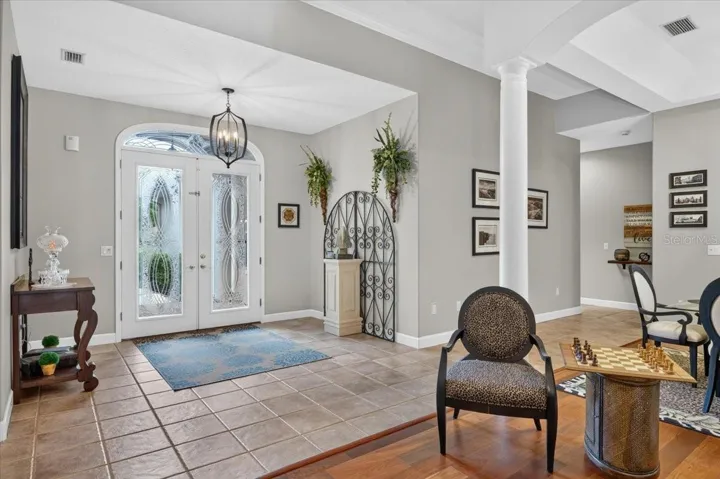 Past the foyer, decorative columns frame the formal living and dining rooms, where 10-foot tray ceilings and generous proportions create an impressive setting for gatherings.