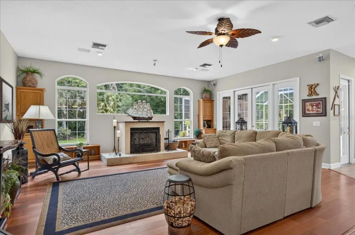 The family room features a gas fireplace, arched windows and French doors opening to the pool and patio area.