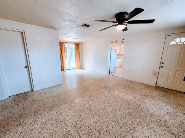 Living room and entry door with ceilin fan
