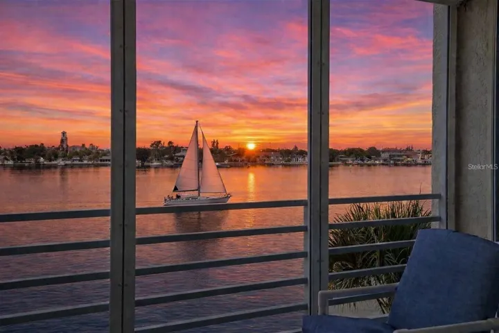 SUNSET BALCONY • IMPACT WINDOWS. A west-facing balcony captures glowing evening skies over the Intracoastal, enhanced by new gemstone floor coverings ON THE BALCONY, hurricane-impact windows, and electric storm shutters