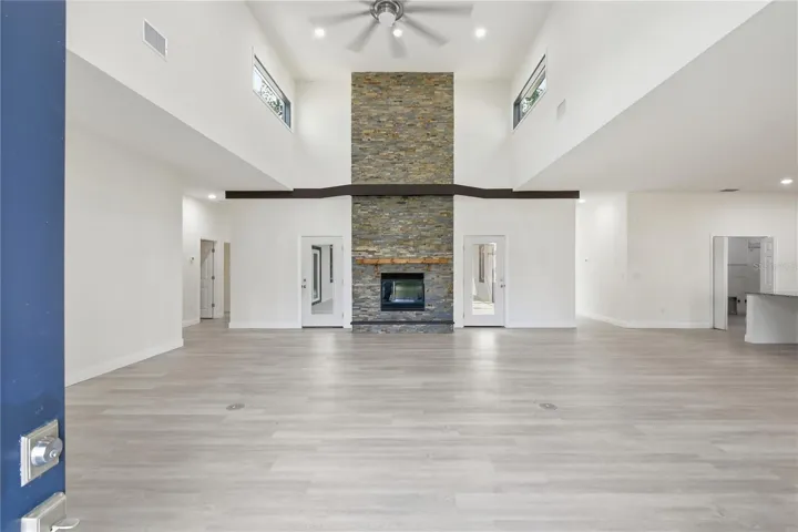 From the moment you walk through the front door, you're greeted by a dramatic open living space with soaring ceilings, expansive sightlines, and a spectacular floor-to-ceiling double-sided stone fireplace