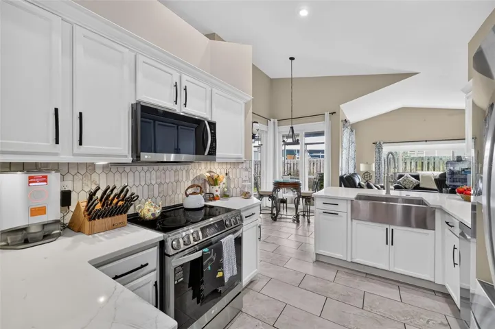The kitchen is light and bright with stainless appliances, farmhouse sink and soft close cabinetry. This room leads to the dining aream living room and family room