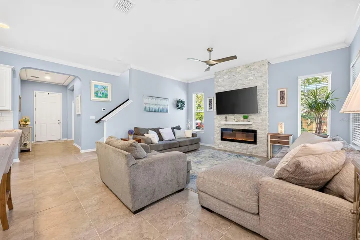The spacious Living Room creates a stunning impression with its custom STACKED STONE ACCENT WALL with sleek electric fireplace, creating a warm yet contemporary gathering space.