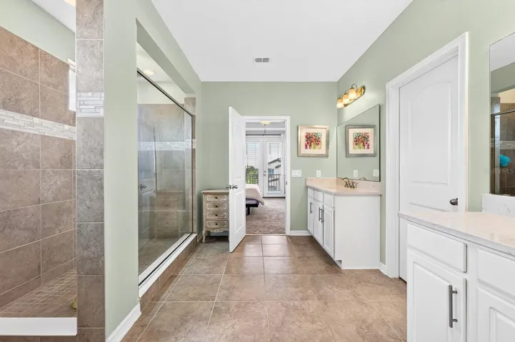 The SPA-INSPIRED EN SUITE BATH offers dual vanities, a huge walk-in shower with built-in bench seating, a private water closet, and a generous walk-in closet.