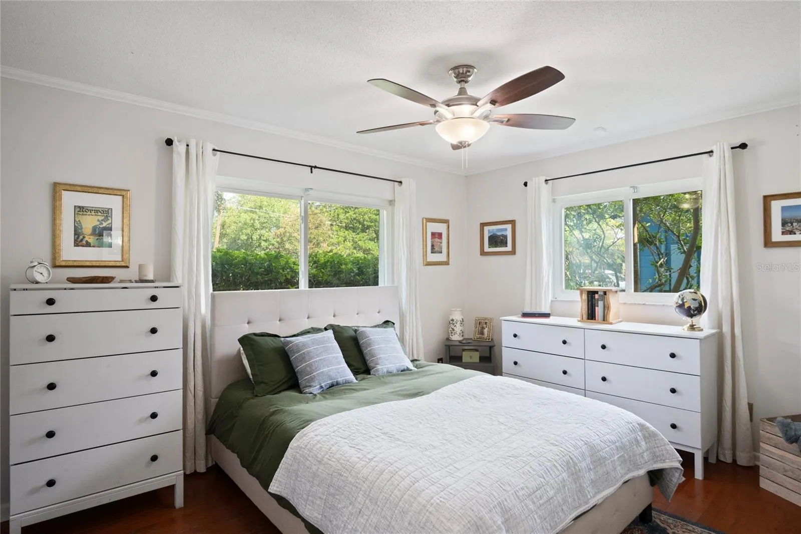 The primary bedroom is light and bright with windows looking out to the west and to the north.