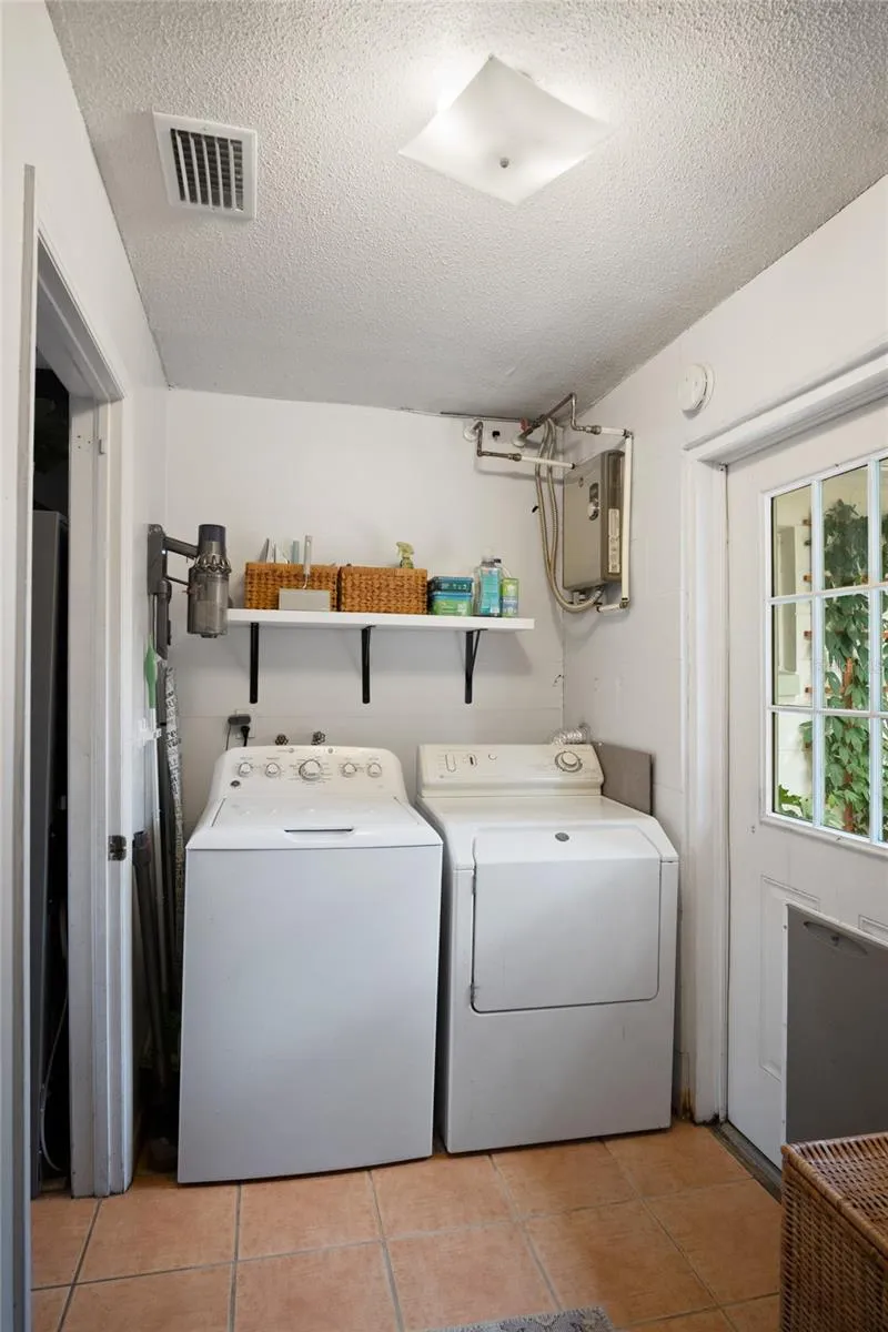 The laundry room leads to the backyard and is where the tankless water heater is located.
