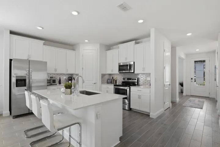 The kitchen features white shaker cabinets, stainless steel appliances and more!