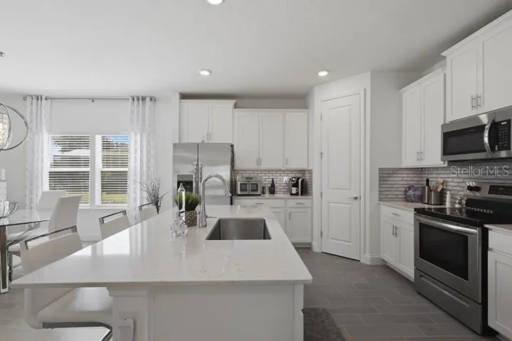 Check out the quartz countertops and high-end wood grain plank style tile flooring that runs throughout the living areas in this home.