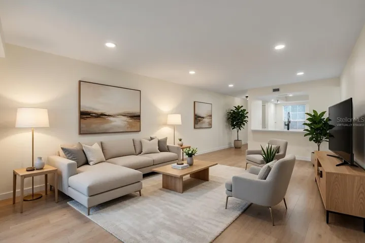 Spacious open-concept living room with luxury vinyl flooring, recessed lighting, and a bright, airy layout - virtually staged