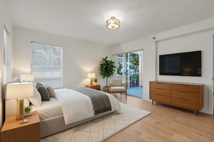 Spacious owner's suite with luxury flooring, natural light, and private lanai access- virtually staged