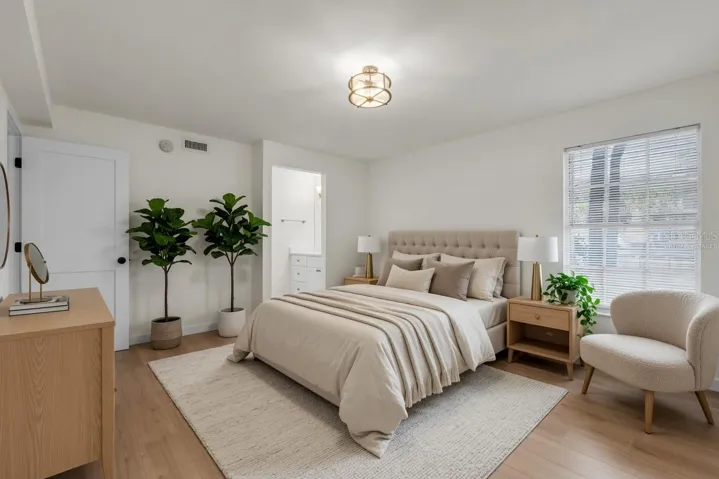 Spacious owner's suite with luxury flooring, natural light, and private lanai access - virtually staged