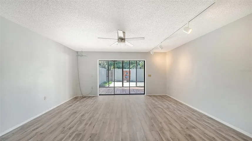 Living room looking through glass enclosed lanai to courtyard
