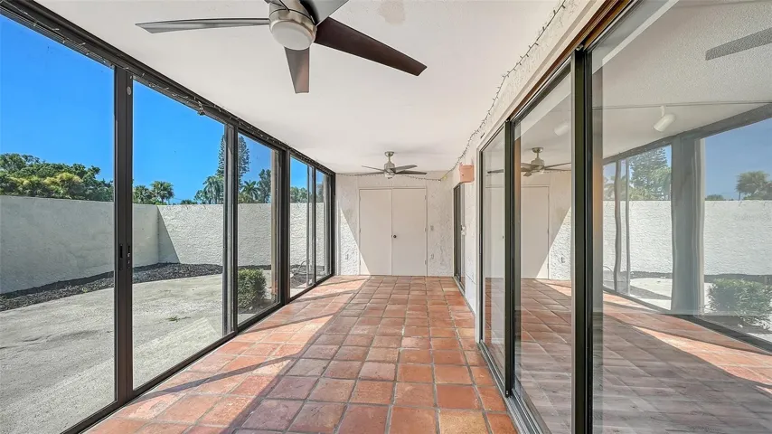 Glass enclosed lanai between living areas and courtyard. spacious storage room at end. Note sliders in living room and between lanai and courtyard are both 8' high