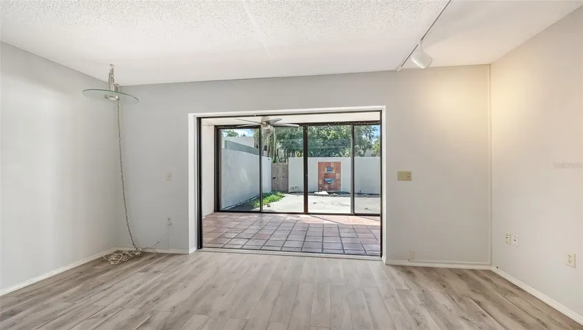 Living room looking through glass enclosed lanai to courtyard