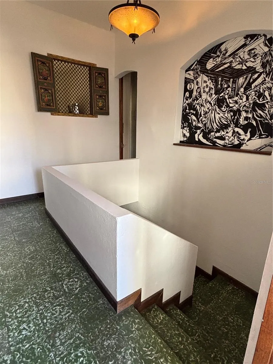 2nd floor staircase area with interior window and mural partition to kitchen.
