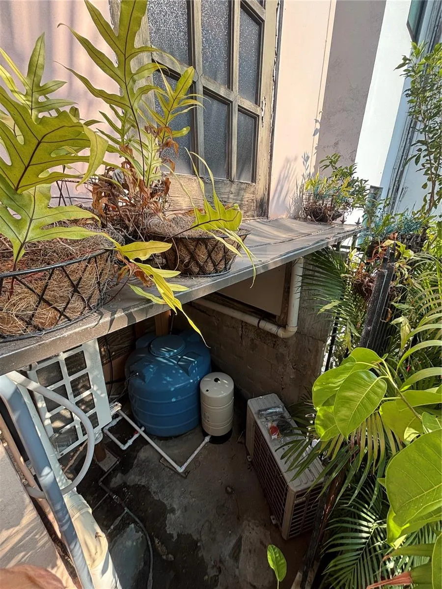 Utility area at the   back of the house (above laundry and below tower staircase) holds air conditioners, cistern, water filter and water pump.