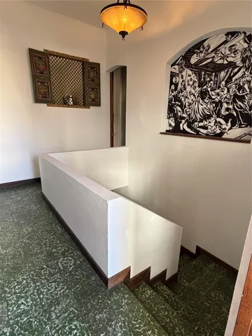 2nd floor staircase area with interior window and mural partition to kitchen.