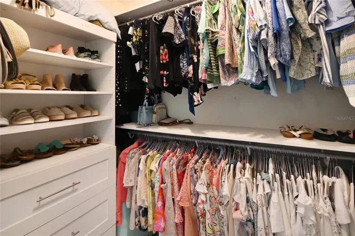 Walk in closet with custom shelving/drawers.