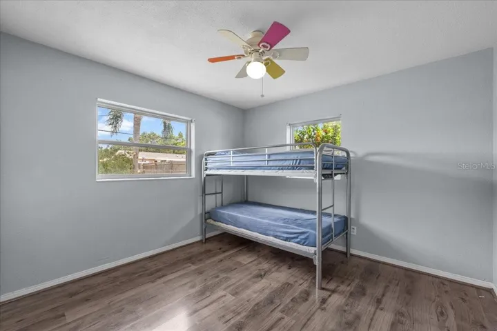 Ample sized second bedroom with nice flooring and ceiling fan.