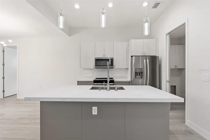 Sleek Kitchen with Quartz Island and Two-Toned Cabinetry