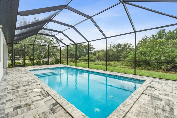 Screen Pool Area with Paver Deck and Peaceful Greenbelt Views