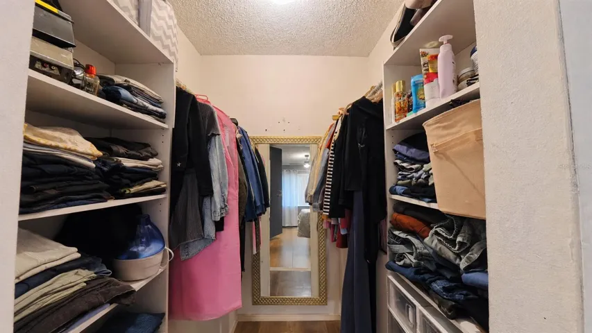 Primary walk-in closet with built-in shelving