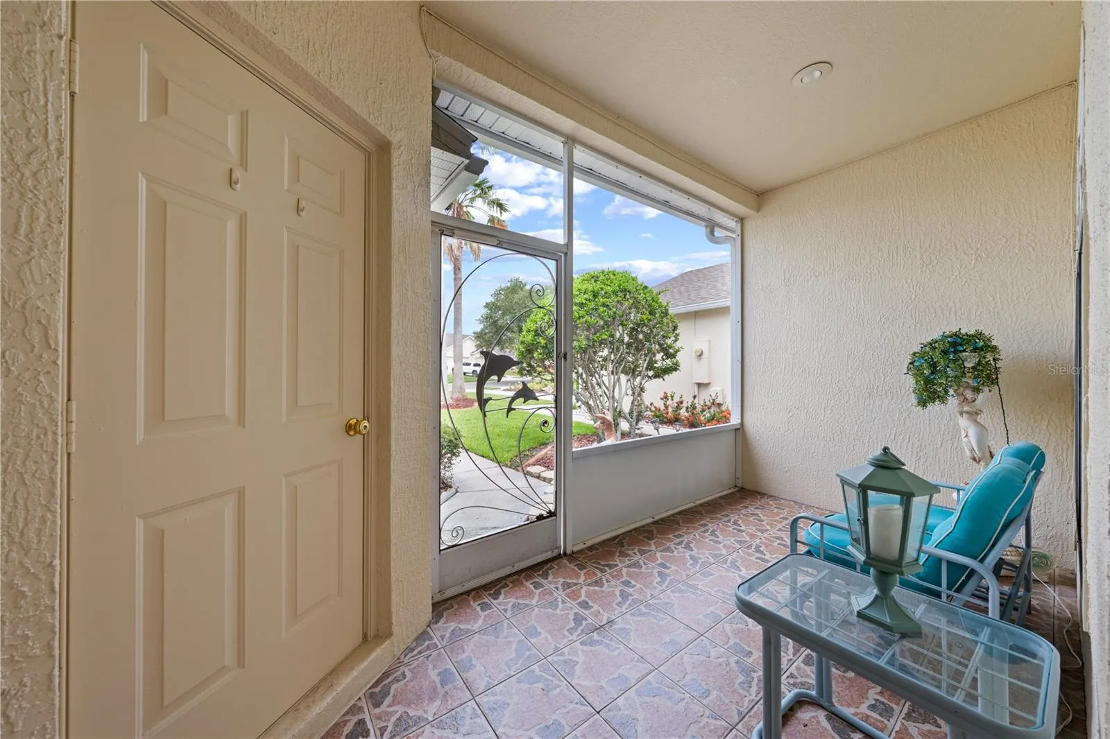 Front porch screened lanai with the door to left leading into the 1 car garage.