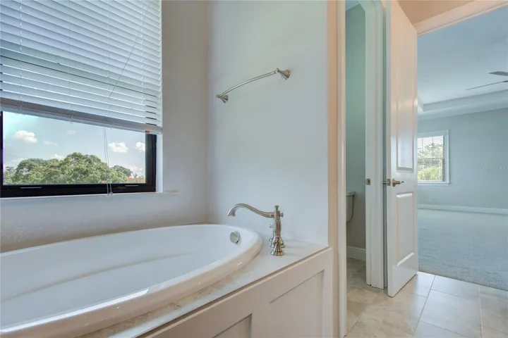 master bath with tub and shower and 2 vanities