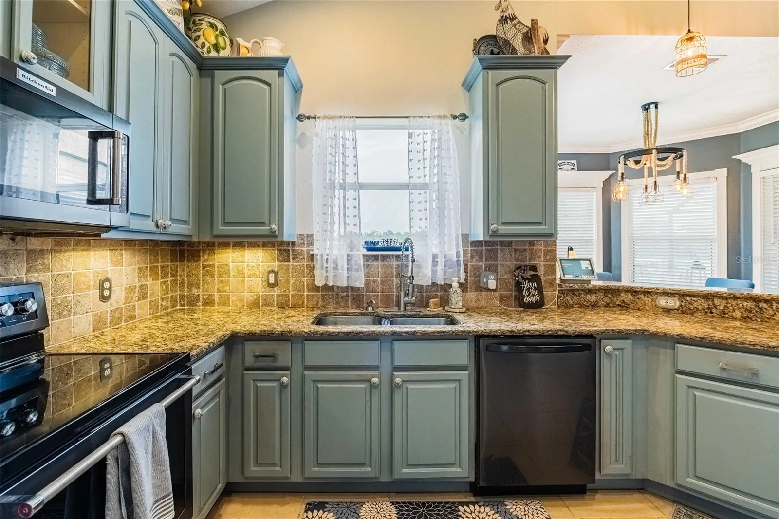 Kitchen with Granite countertops and tile backsplash overlooking the backyard