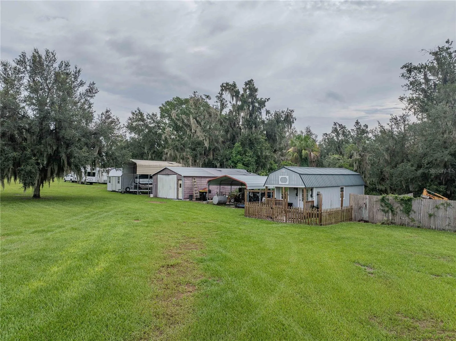 Tiny house with porch, 2 car carport, workshop, RV carport, shed