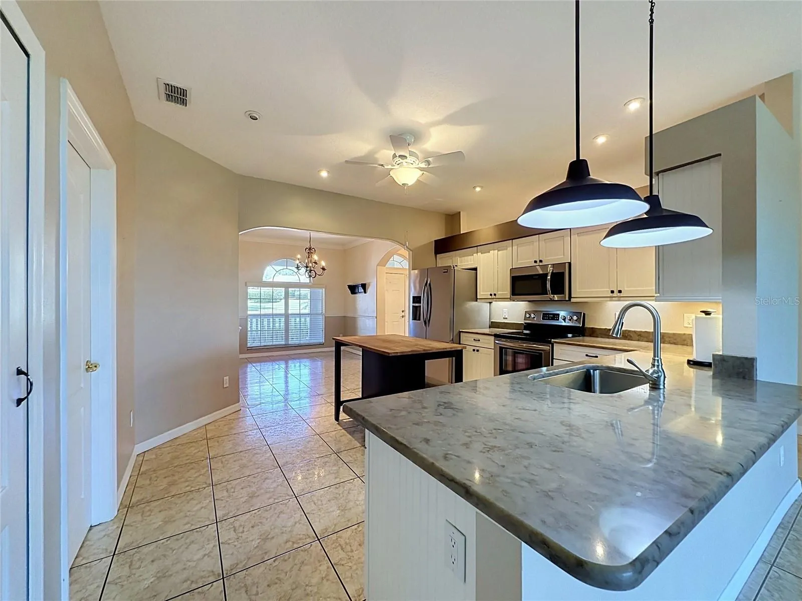 Kitchen has granite countertop and stainless steel sink