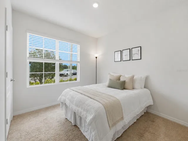Spacious bedroom featuring ample room for a queen-size bed and a full dresser set, offering a comfortable and functional living space.