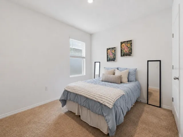 Bright and fresh guest bedroom featuring ample space for a queen-size bed and additional furniture such as a dresser or armoire.